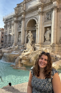 A woman smiling in front of an Italian monument. 